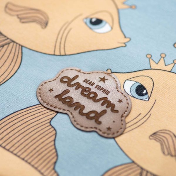 Detailfoto van een blauwe vest met goudvis print van het merk Dear Sophie.