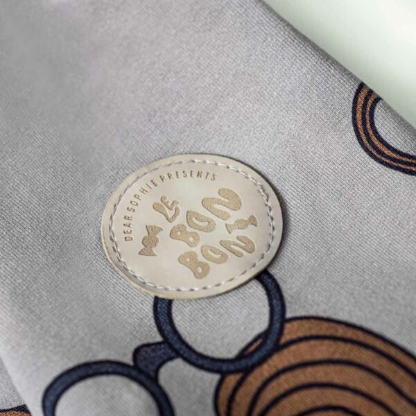 Detailfoto van een grijze onesie met snor print van Dear Sophie.